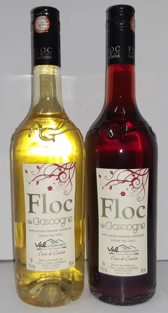 Deux bouteilles de Floc de Gascogne: une dorée (blanc) et une rouge. Labels: AOC Gascogne, 17% Vol, 750ml, Cave de Condom.