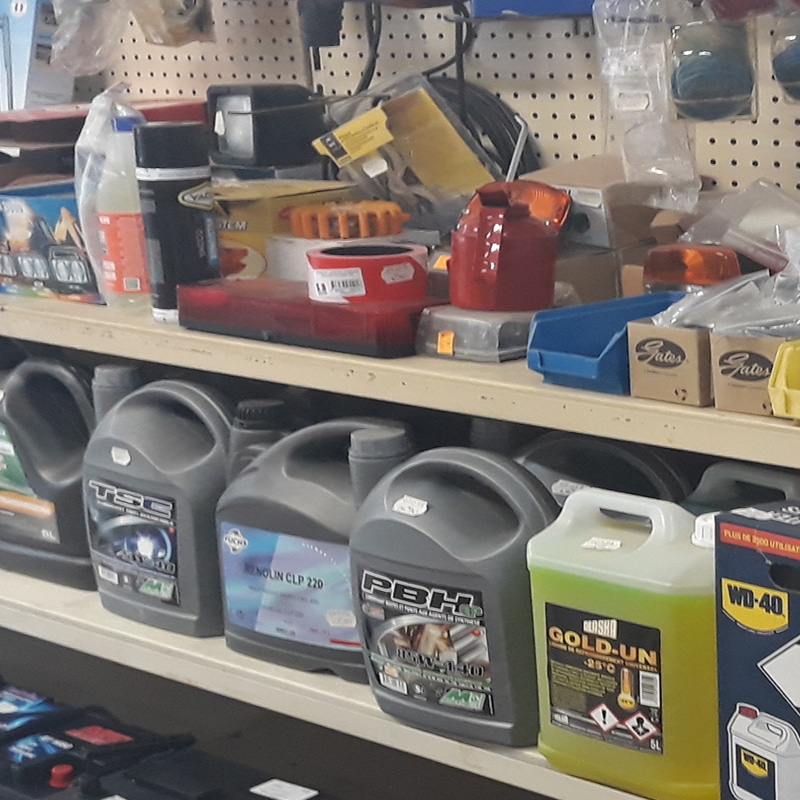 Étagères remplies de fluides automobiles, lubrifiants (Fuchs RENOLIN CLP 220, PBH, GLASKO GOLD-UN), WD-40 et accessoires divers.