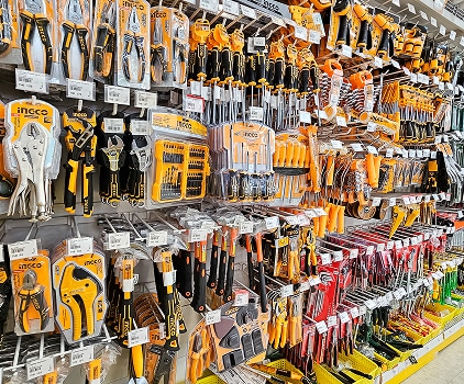 Présentoir mural d'outils à main de marque Ingco, comprenant pinces, clés, tournevis et marteaux, emballés en jaune et noir dans un magasin de quincaillerie.