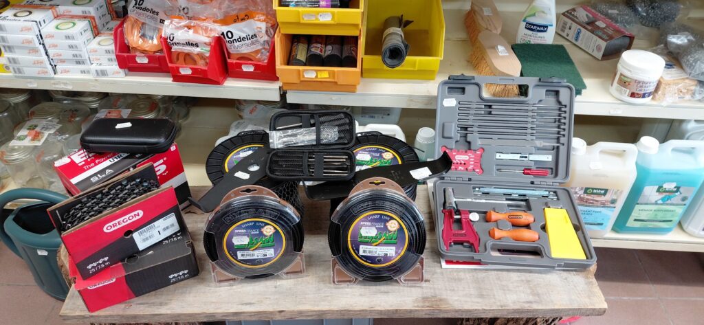 Outillage et Accessoires de Jardin Oregon et Nylsaw Équipement d'entretien de jardin : fils Nylsaw, chaînes Oregon et kit d'outillage sur une étagère de magasin.